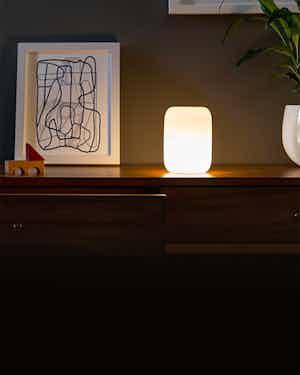 glow light next to art print on dresser in dim room
